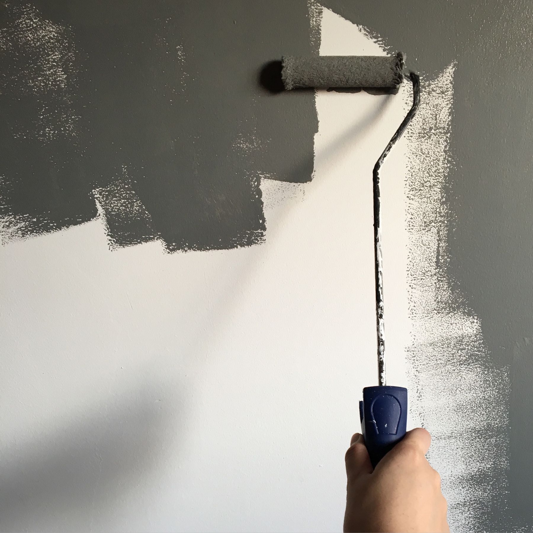 Roller applying fresh paint to an interior wall